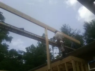 Carpenter setting a ridge beam over a new addition frame — Ice Dam Removal by Roofing Brothers in South Barre