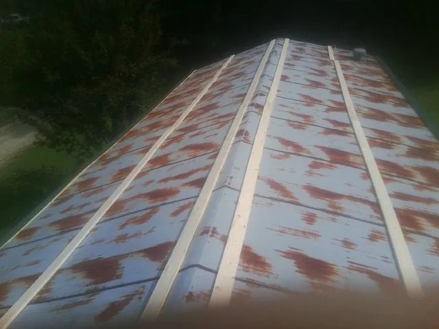 Rusted metal roof panels with new wood purlins before replacement — Storm Damage Roof Repair in South Barre by Roofing Brothers