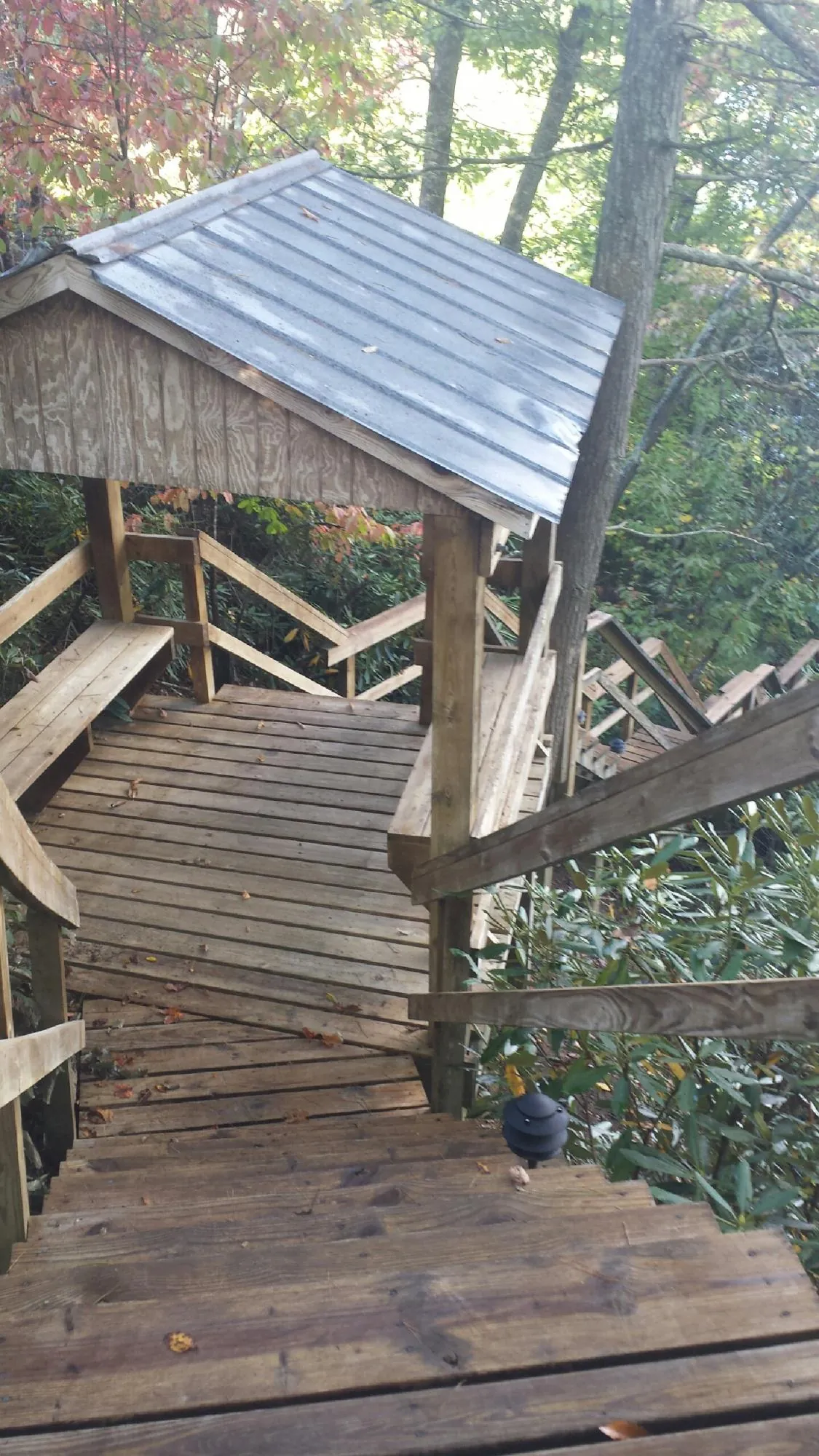 Metal roofed shelter over wooden steps on a wooded walkway — Skylight Repair & Installation work by our crew in South Barre