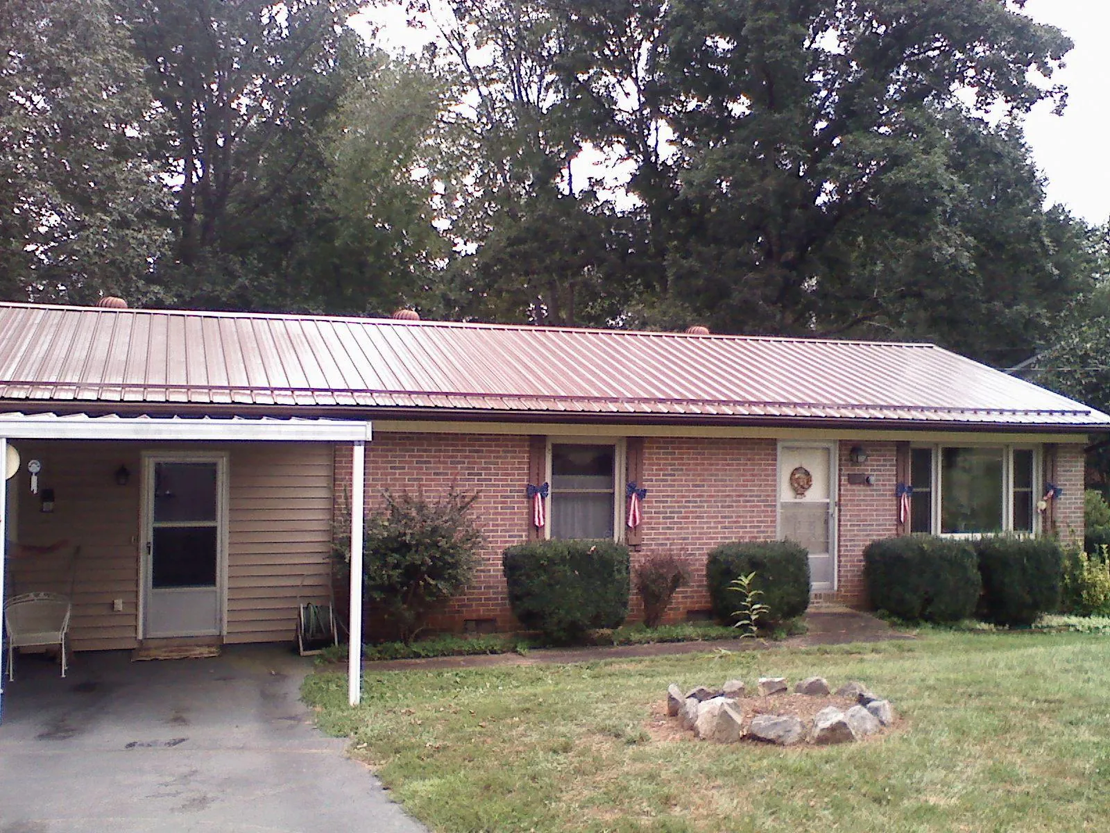 Bronze metal roof and carport on a brick ranch home — Roof Repair work by our crew in South Barre